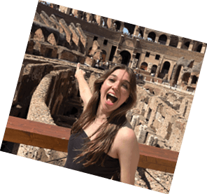 A woman is standing on a bridge in front of a building with a large arch. AI generated content